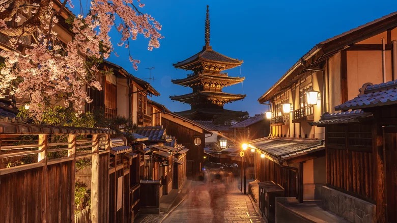 Kyoto street at dusk with a pagoda and cherry blossoms